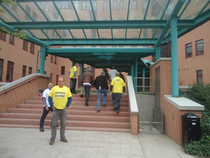 four men walking up a flight of stairs towards a building