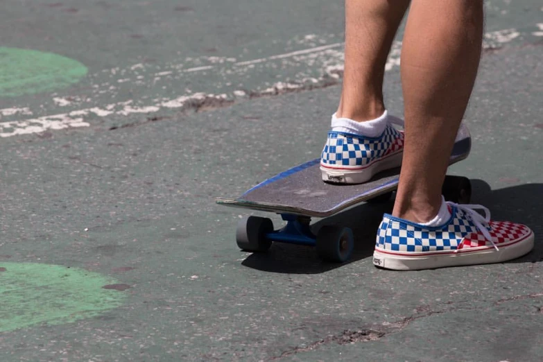 a close up of someone standing on a skateboard on the street