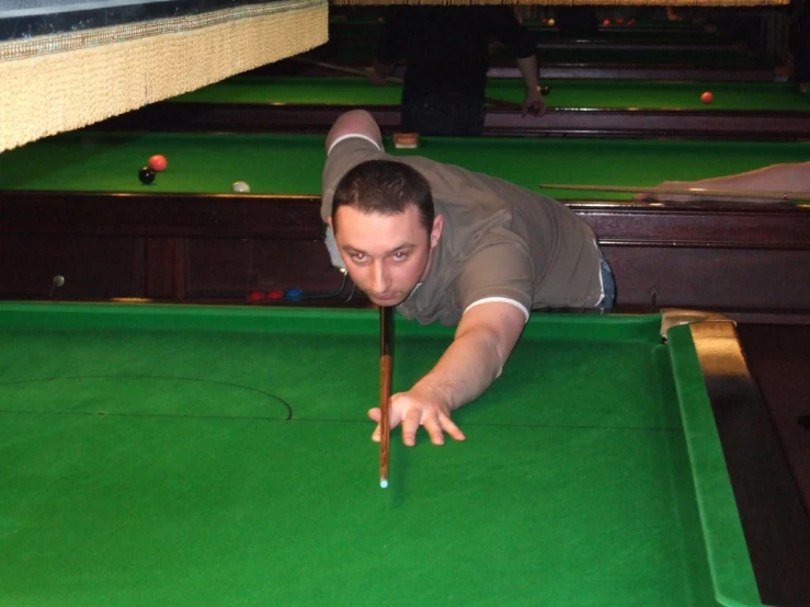 a man leaning over a pool table to check the ball