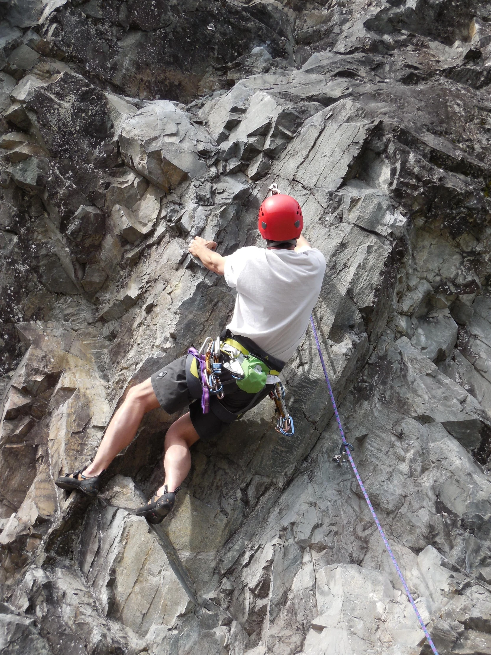 a man sitting on top of a rock covered mountain