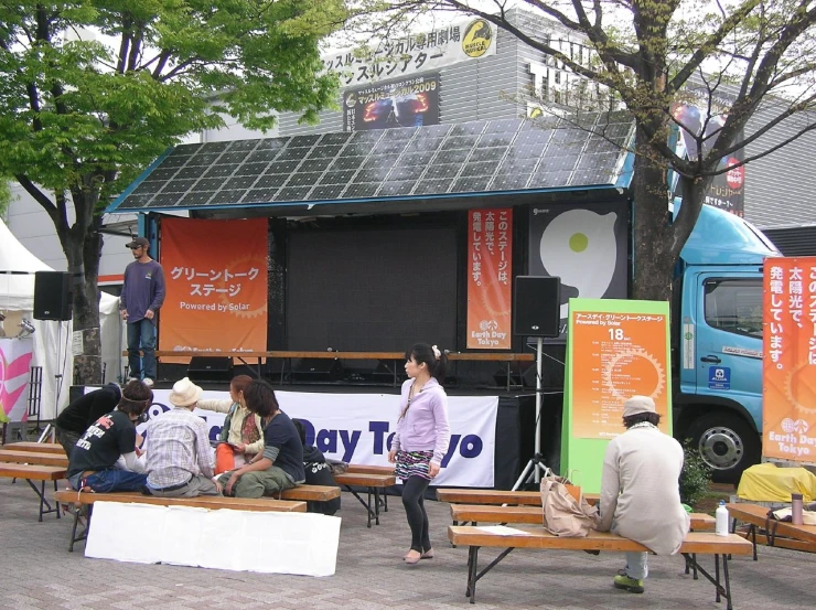 people sitting on benches watching a bus on the side walk