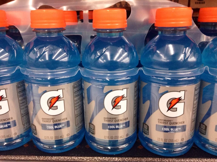 a line of gatorade water bottles are on the shelf