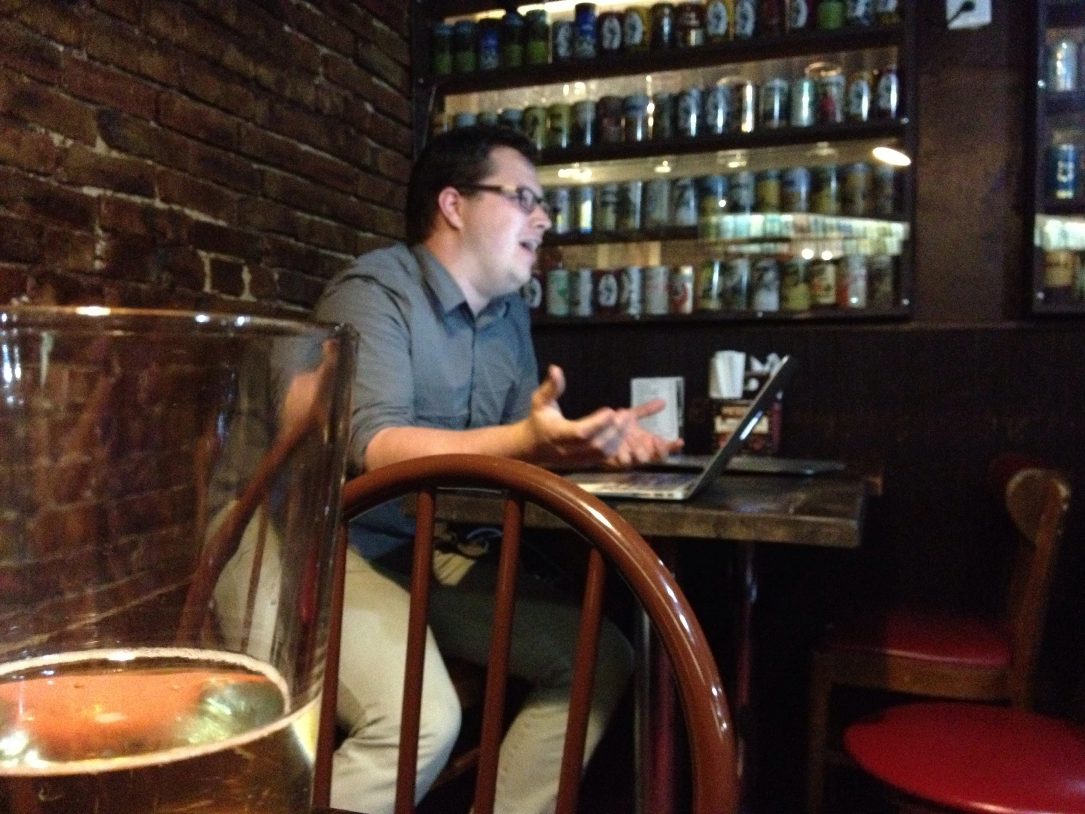 a man sitting at a table working on his laptop computer