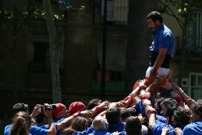 people wearing blue shirts and red hats are being tossed around