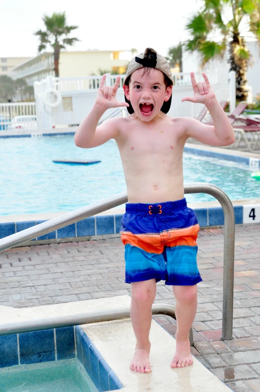 a boy that is standing up near a pool