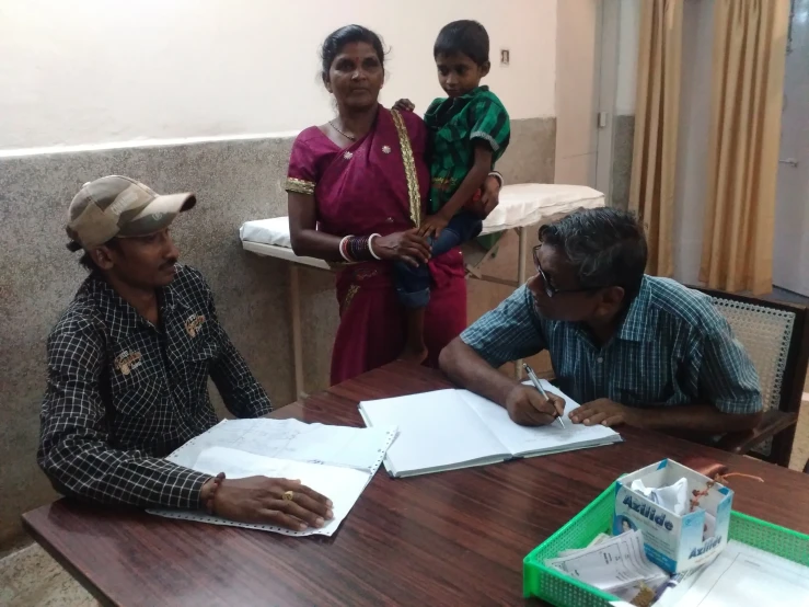 people sitting at a table with papers and pen