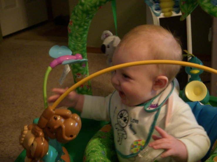 a smiling baby sitting in a toy chair