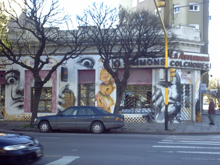 a car is parked on the corner outside a theater