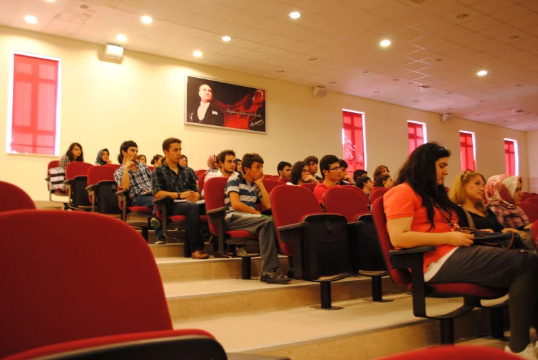 many people are seated on the stairs of an auditorium