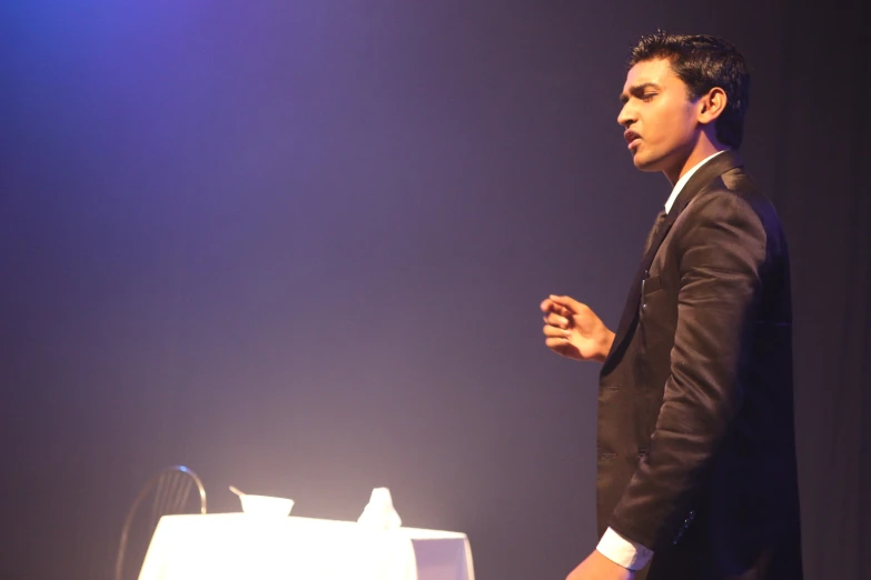 young man in suit and tie standing up to speak