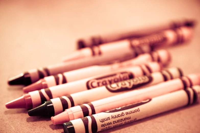 four brown and pink crayons laying on a table