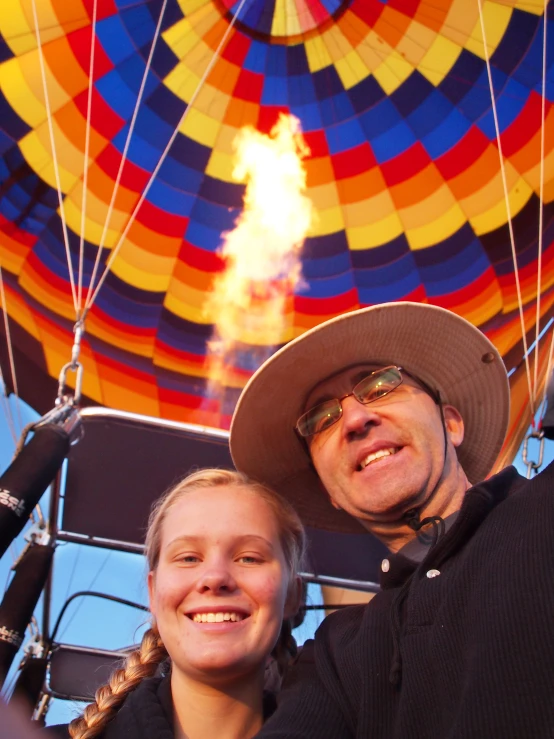 a man and a woman standing near an open air balloon