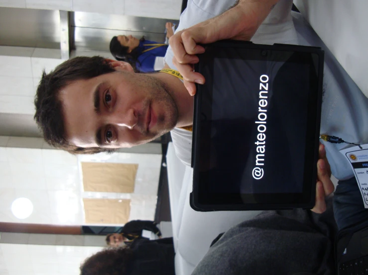 a man holding up a tablet with matololenzo on it