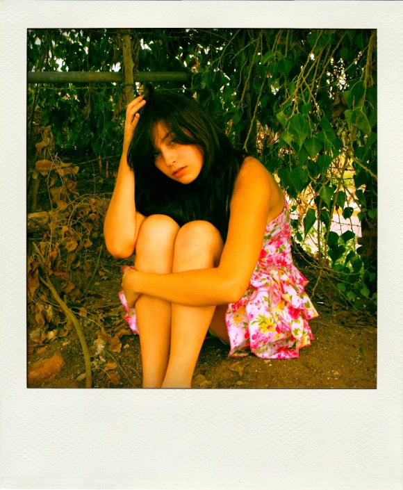 a girl sitting in front of a tree