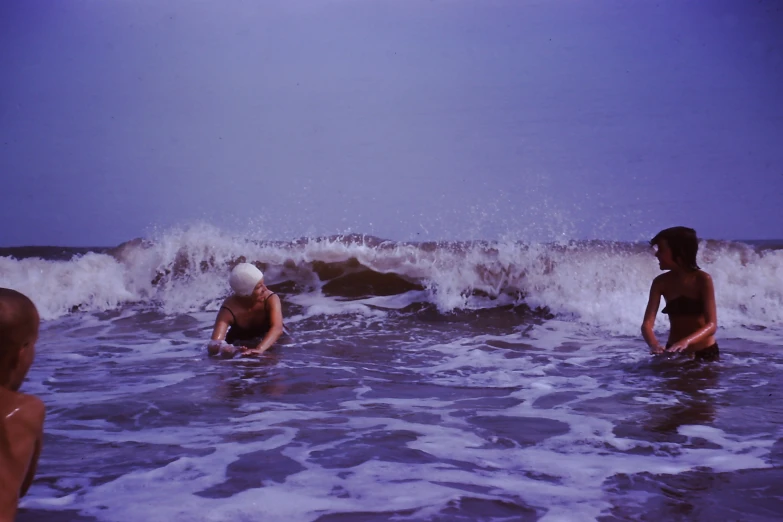 two people sit in the waves at the beach