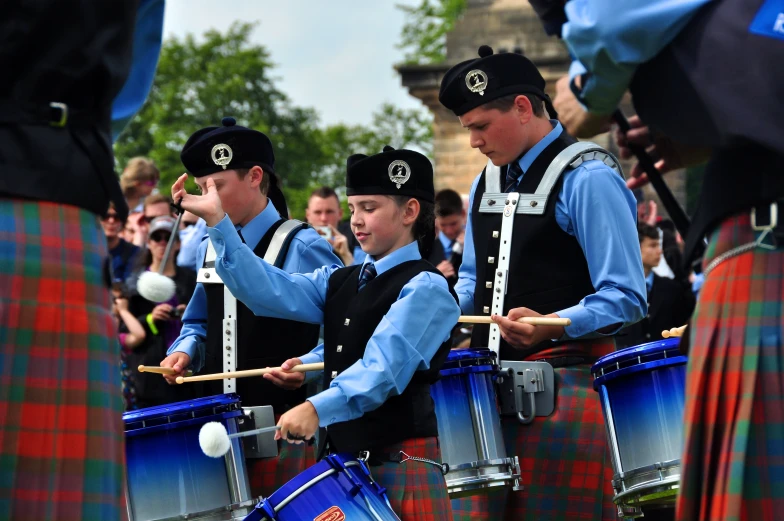 several men in kilts playing instruments and drum