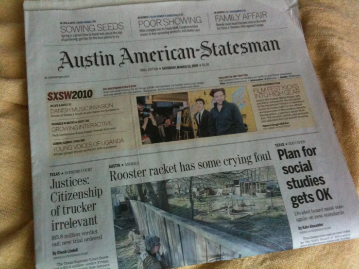 a newspaper on top of a bed with a person standing in the background