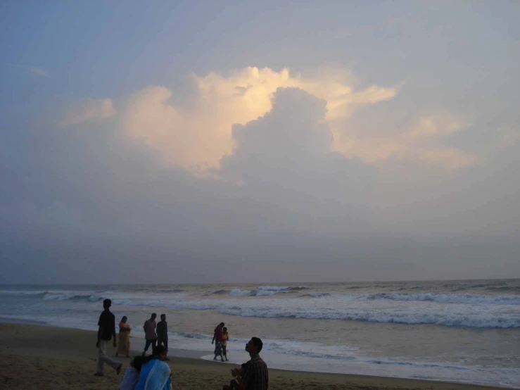 a group of people standing on top of a sandy beach