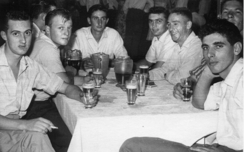 black and white pograph of people at a table eating