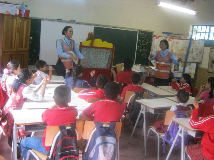 children and teachers are in the classroom attentively listening to their teacher