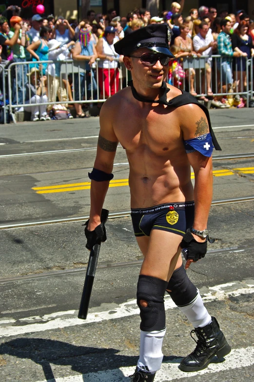 a shirtless man with a baseball bat walking in an outfit