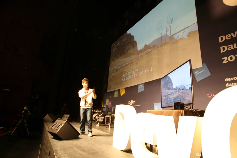 a person that is standing on stage with his feet crossed