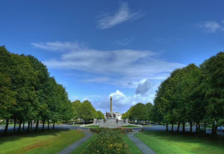 view of a fountain in a park with trees and grass