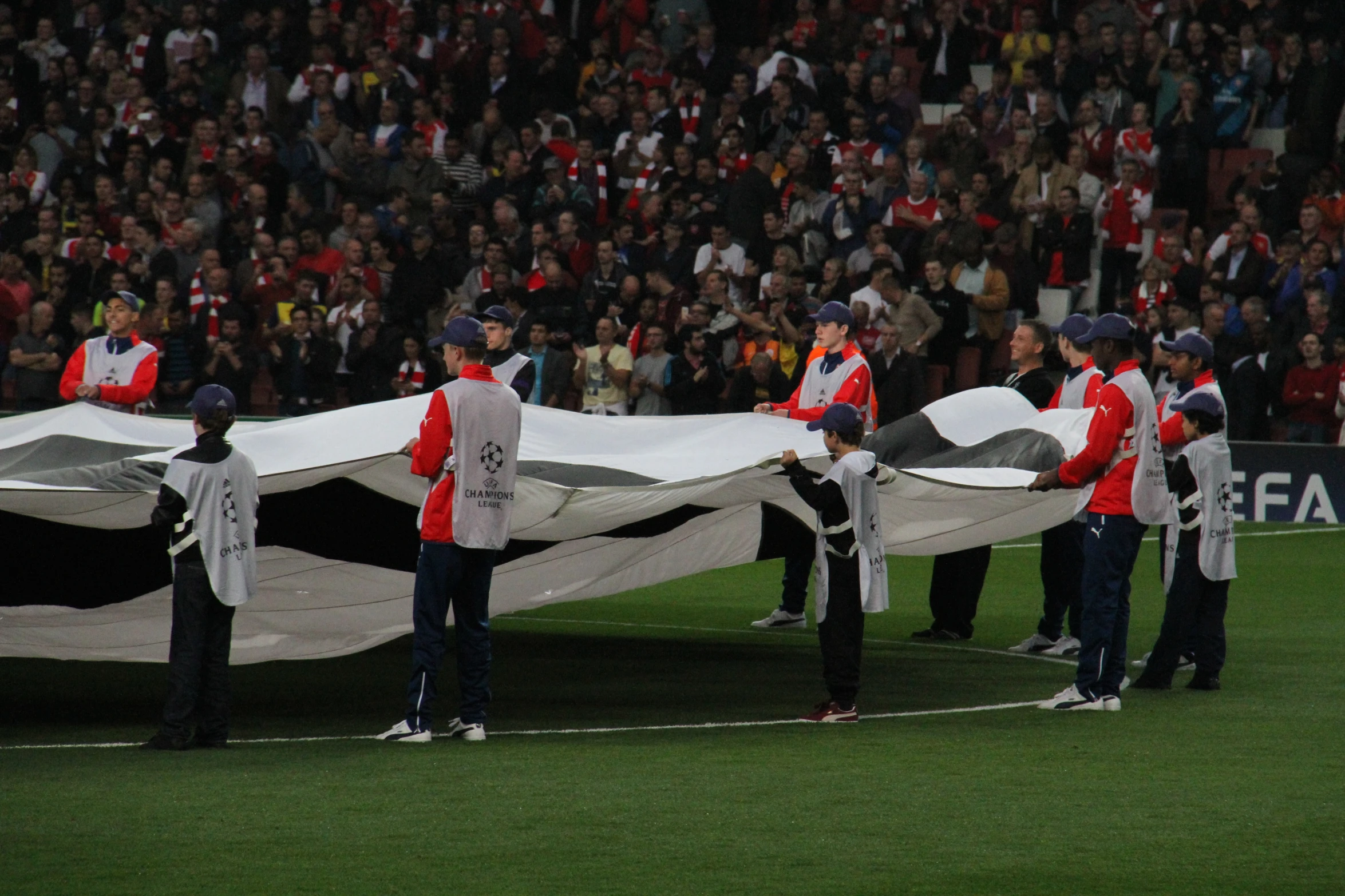 people are carrying a large tarp on a field