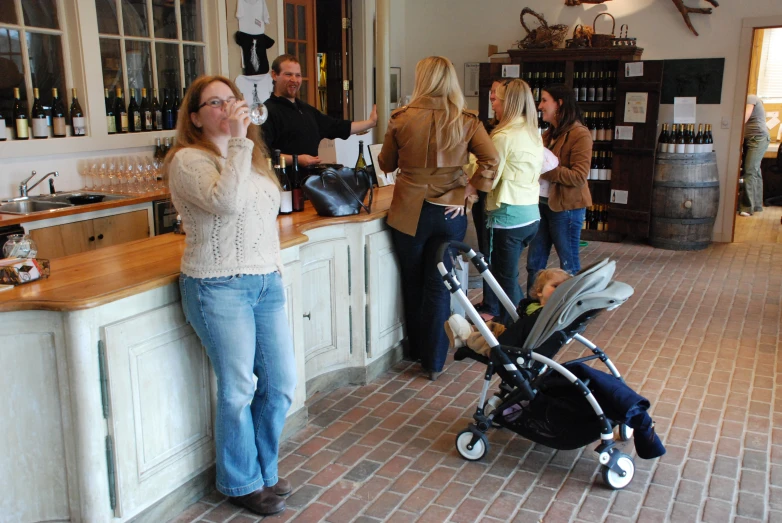 several people are in the bar with an infant carriage
