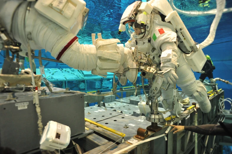 astronaut moving around a space station in the ocean