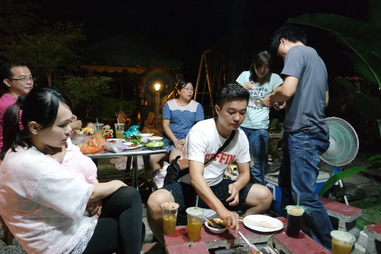 several people gathered together at a party with a cake