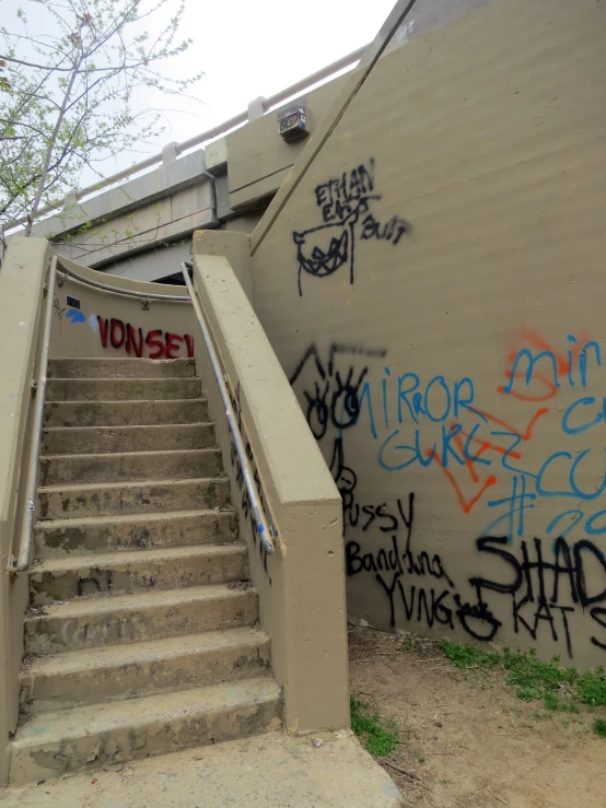 graffiti on the walls of an escalator leading to a stair ramp