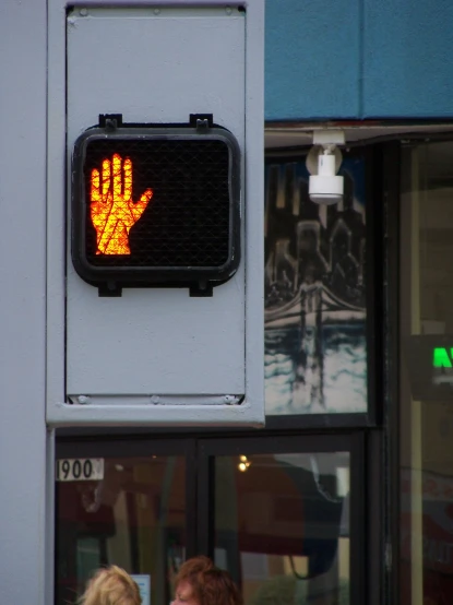 a pedestrian traffic sign indicating a yellow hand or hand is coming to the crossing point