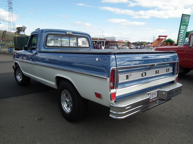 the back end of an old blue and white pickup truck