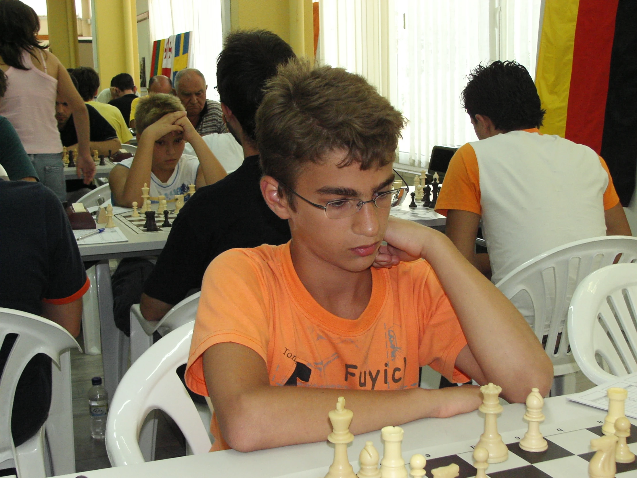 a man sitting at a table next to a chess board