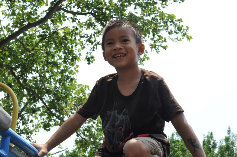 a boy sitting on top of a playground rail