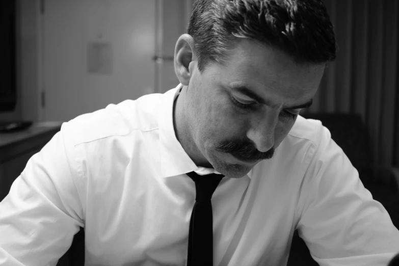 a man in shirt and tie looking at papers