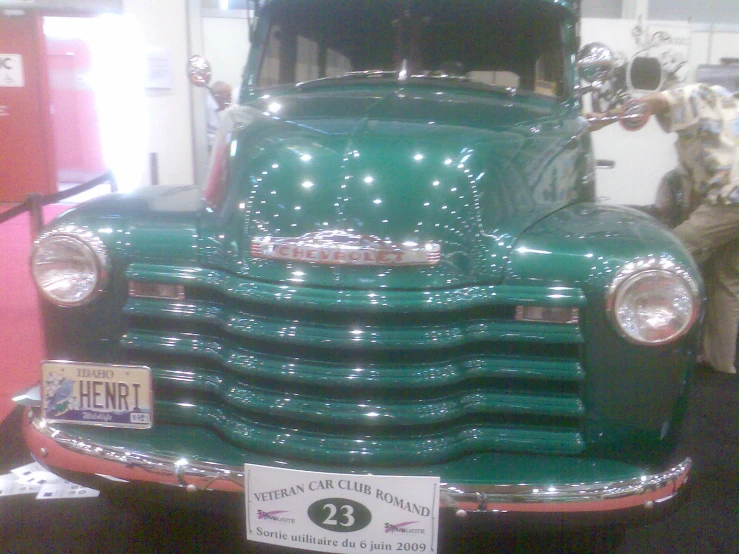 the green, shiny truck is parked on display