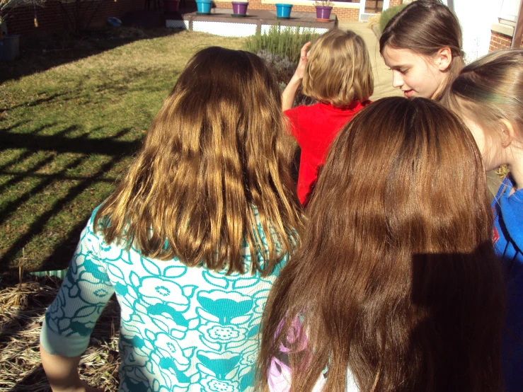 the group of girls are looking down at the ground