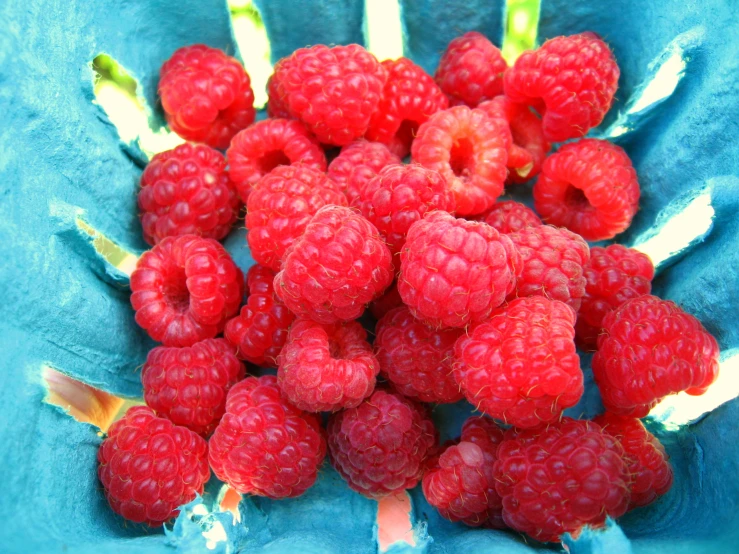 a pile of raspberries laying next to another bunch