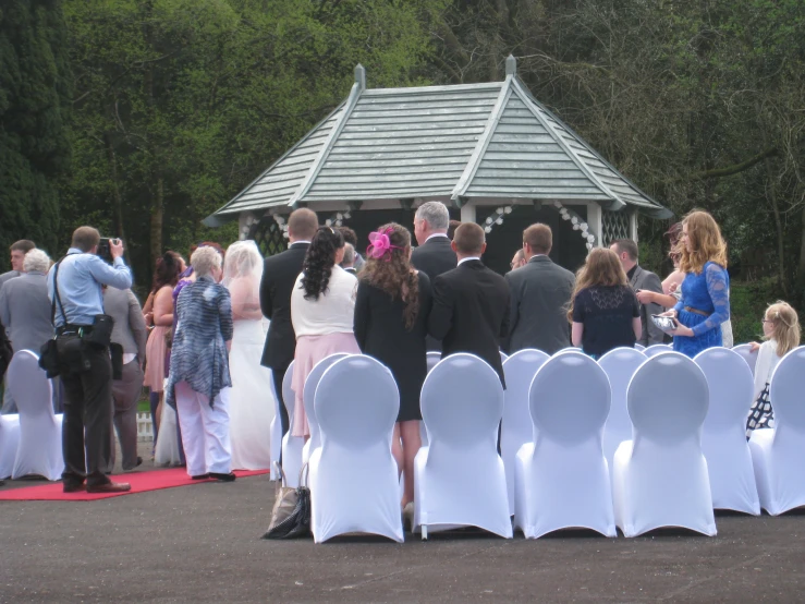 the back view of a group of people and their white chairs