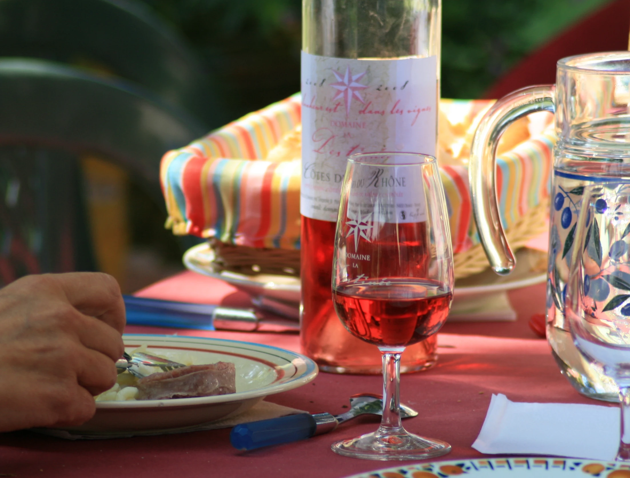 the man is eating at the table next to the wine