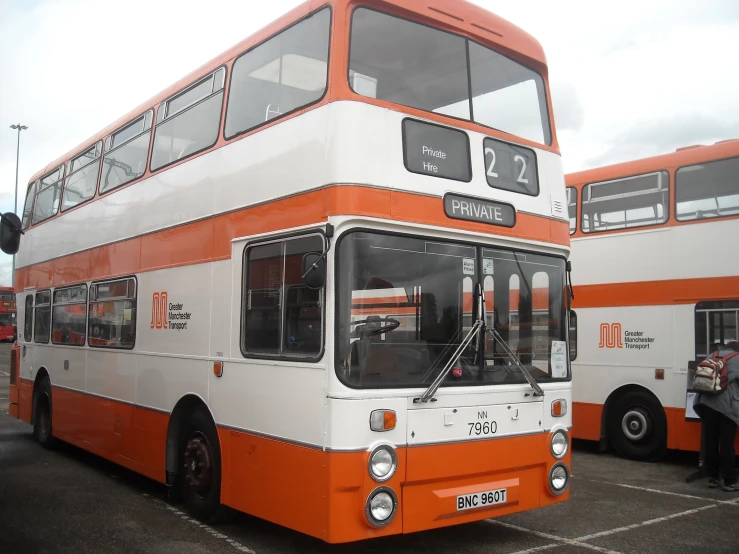 there are two double decker buses in this parking lot