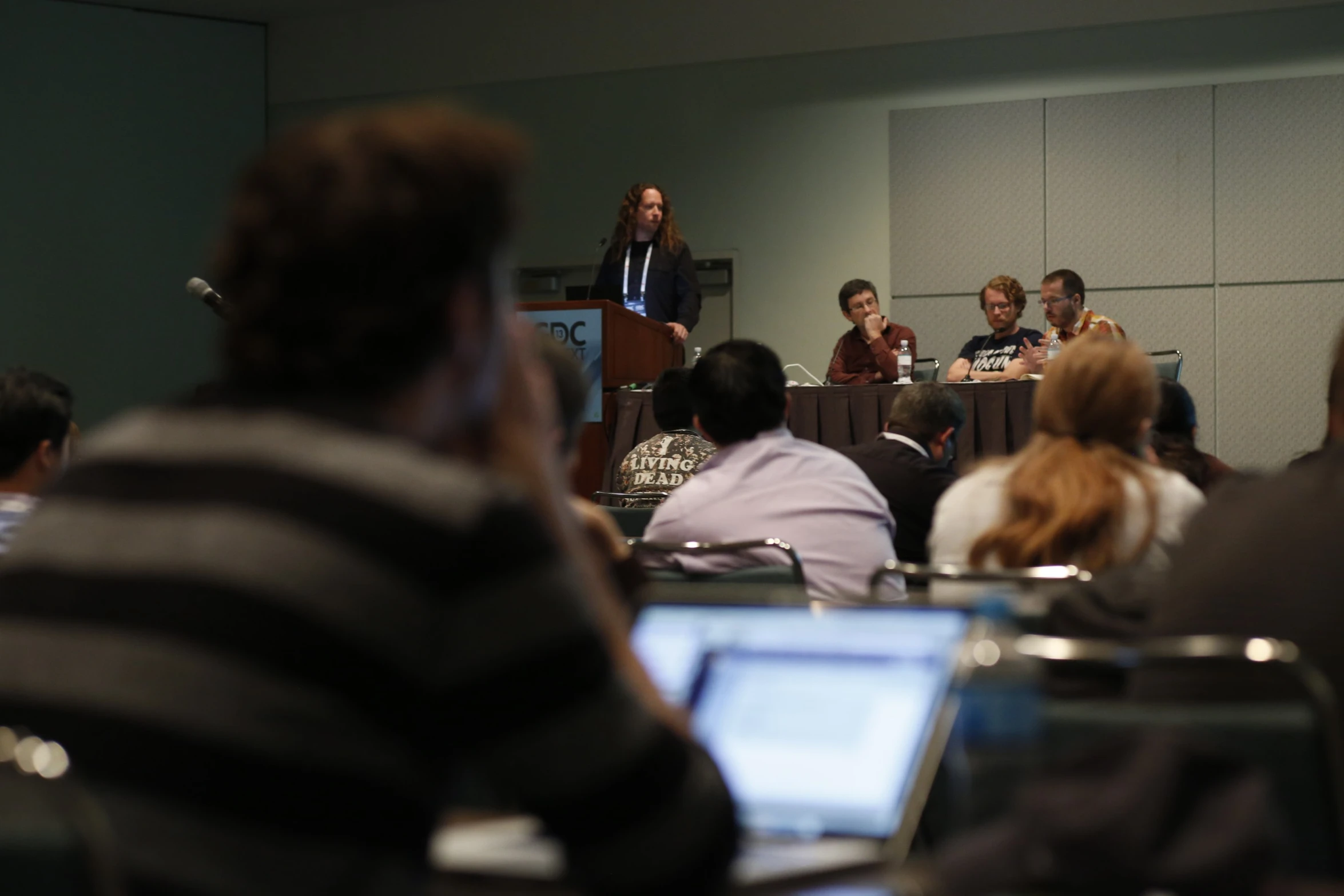 a group of people in a room listening to a person speak