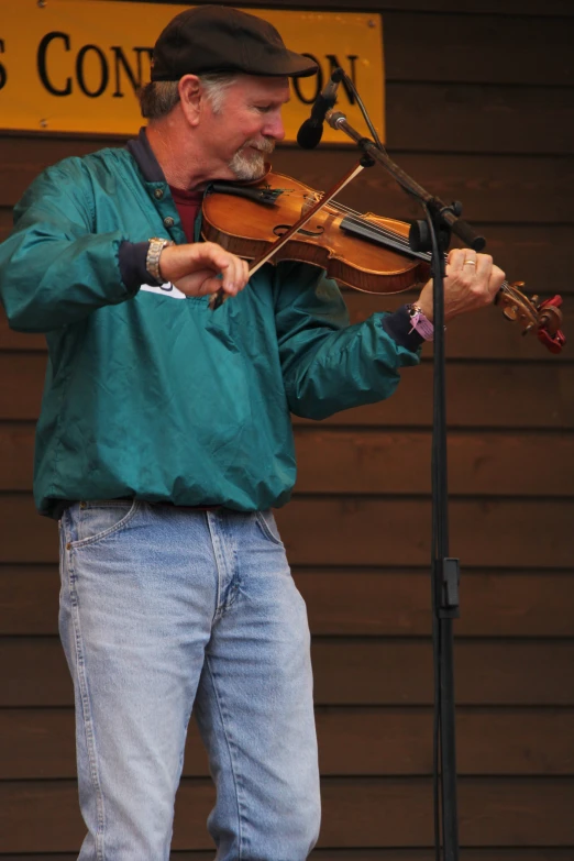 a man playing the violin with a microphone in front of him