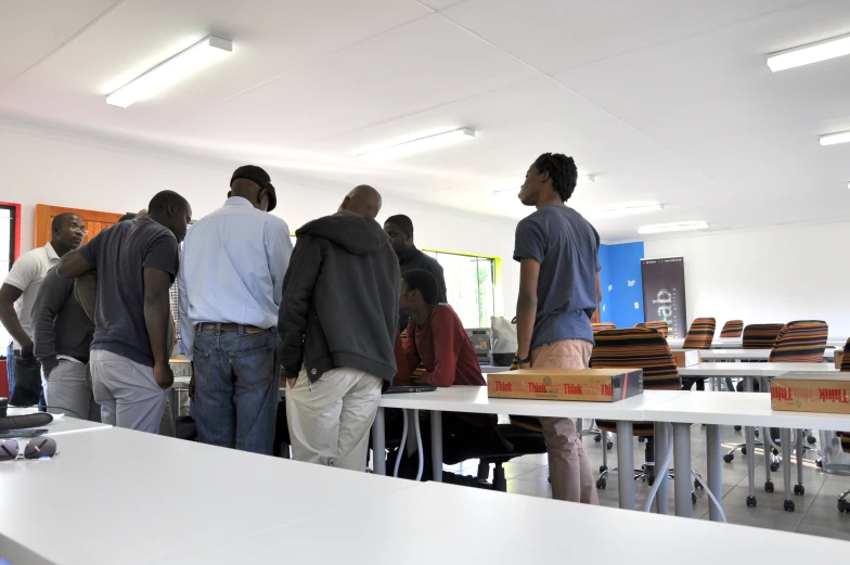 several men standing around a desk inside of a building