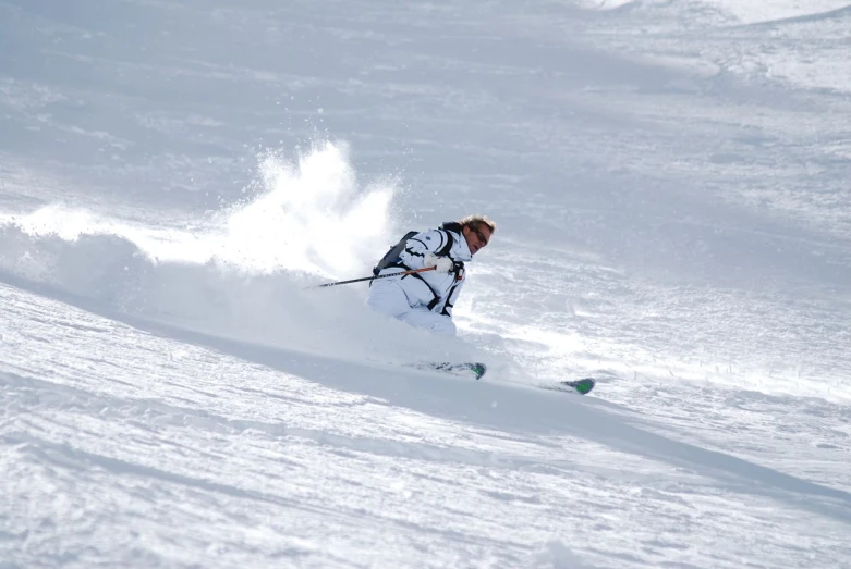 a man in blue jacket skiing down a snow covered slope