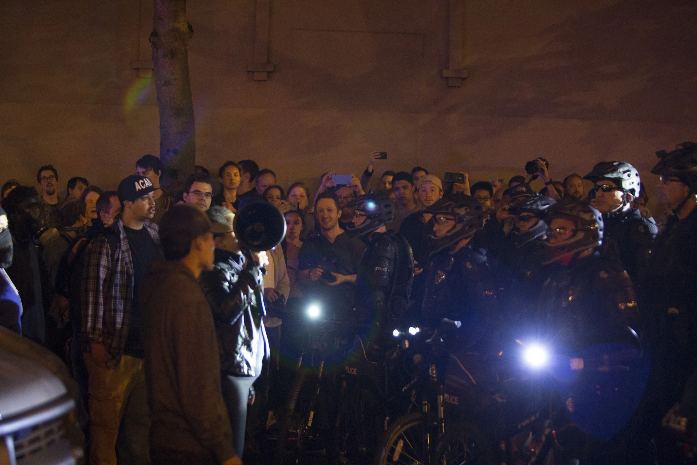 a large group of people standing behind their bikes with cameras