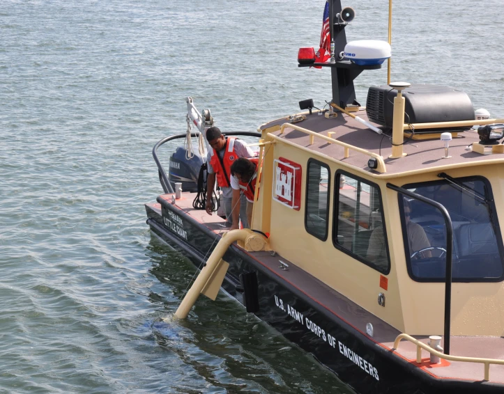 a man standing on the deck of a tug boat