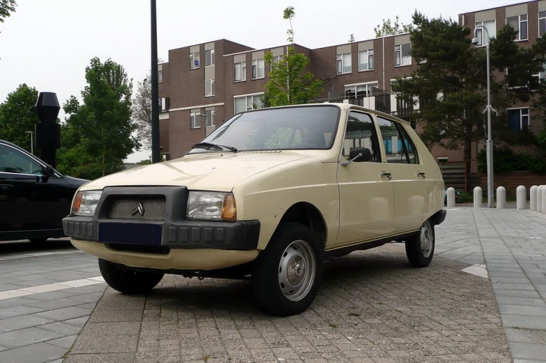 a large beige colored car parked on the side of the road